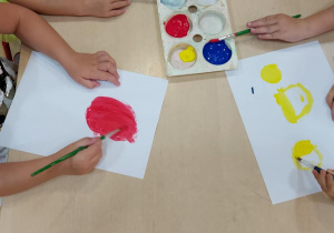 Grupa średniakó maluje farbami swoje kropki